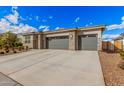 Charming home exterior with a stone facade, neutral color palette, and a spacious three-car garage at 18434 W Chama Dr, Surprise, AZ 85387