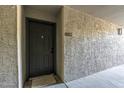 Exterior shot of a unit's black front door with visible unit number surrounded by textured stucco wall at 2025 E Campbell Ave # 265, Phoenix, AZ 85016