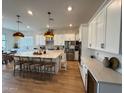 Modern kitchen with island, stainless steel appliances, white cabinets, and a dining area, creating an inviting space at 22703 E Alyssa Rd, Queen Creek, AZ 85142