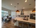 Bright kitchen featuring white cabinets, stainless steel appliances, a large island, and an adjacent dining area at 22703 E Alyssa Rd, Queen Creek, AZ 85142