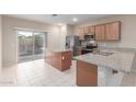 Well-lit kitchen boasts an island and sliding doors to the backyard at 274 W Kona Dr, Casa Grande, AZ 85122