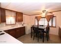 Cozy kitchen and dining area features wood cabinets, a dining table, and included washer and dryer at 303 S Recker Rd # 152, Mesa, AZ 85206