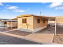 Manufactured home with covered parking and tidy gravel landscaping at 535 S Alma School Rd # 60, Mesa, AZ 85210