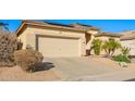 Single-story home with a neutral exterior, two-car garage, desert landscaping, and solar panels at 6442 W Cavedale Dr, Phoenix, AZ 85083