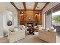 Cozy living room features a stone fireplace and wooden beam ceiling details at 6626 E Oberlin Way, Scottsdale, AZ 85266