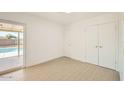 Clean bedroom with light tile floors, a sliding glass door, and white double door closets at 726 N 78Th St, Scottsdale, AZ 85257