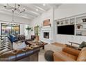 Open living room featuring a fireplace, beamed ceilings, built-in shelving, and a leather sofa at 8336 E Calle De Alegria --, Scottsdale, AZ 85255