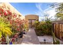 Desert home's charming entrance is accentuated by colorful flowers and lush desert landscaping along a private walkway at 8502 E Cave Creek Rd # 53, Carefree, AZ 85377