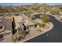 Aerial view of a desert home featuring desert landscaping, a tile roof, and a circular street at 8634 E Kael Cir, Mesa, AZ 85207