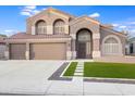 A two-story home with a tile roof, arched windows, and a well-manicured lawn offers curb appeal at 9144 W Quail Ave, Peoria, AZ 85382