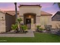 Warm and welcoming front entrance featuring a charming covered porch, desert landscaping, and a wood door at 9544 E Irwin Ave, Mesa, AZ 85209