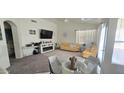 Bright living room featuring neutral colors, a fireplace, and glass dining table at 9614 W Mary Ann Dr, Peoria, AZ 85382