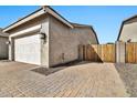 Charming home exterior with a two-car garage, brick driveway, and decorative accents at 9388 W Cashman Dr, Peoria, AZ 85383