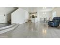 Open-concept space showcasing tile floors, stairs to the upper level, and a view of the kitchen at 12054 W Aster W Dr, El Mirage, AZ 85335