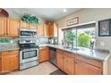 Well-lit kitchen featuring stainless steel appliances, granite countertops, and wood cabinetry at 14223 W Powderhorn Dr, Surprise, AZ 85374