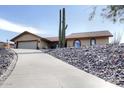 Desert home with a red tile roof, low maintenance desert landscape and a long driveway at 15445 E Thistle Dr, Fountain Hills, AZ 85268