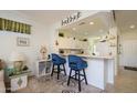 Cozy breakfast nook features stylish blue chairs and a view into the adjacent kitchen area at 15770 W Remington Dr, Surprise, AZ 85374