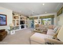 Bright living room with a large sectional sofa, custom built-ins, and sliding glass doors to the backyard at 15770 W Remington Dr, Surprise, AZ 85374
