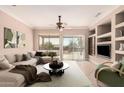 Bright living room featuring a large sectional sofa, neutral walls, ceiling fan, and sliding glass doors to the backyard at 17815 W Calistoga Dr, Surprise, AZ 85387