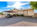 Ranch style home featuring a desert landscape and covered parking area at 19412 W Clarendon Ave, Litchfield Park, AZ 85340