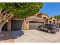 Three-car garage with ample parking space, a well-maintained driveway, and mature shade tree at 408 E Silverwood Dr, Phoenix, AZ 85048