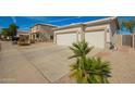 Wide driveway leading to a two-car garage of a home with desert landscaping at 502 E Mountain View Rd, San Tan Valley, AZ 85143