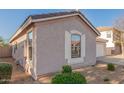 Side view of the house with neutral stucco, white trim, and landscaped rock ground covering at 665 E Winchester Way, Chandler, AZ 85286