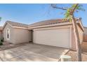 Attached two-car garage with a driveway and low-maintenance landscaping at 665 E Winchester Way, Chandler, AZ 85286
