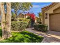 Charming home entrance with landscaped greenery, a gated walkway, and vibrant bougainvillea at 7740 E Gainey Ranch Rd # 36, Scottsdale, AZ 85258