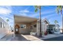 Charming tan home featuring a carport, palm trees, and desert landscaping at 834 S Beryl Dr, Apache Junction, AZ 85119