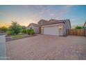 Beautiful home showcasing a paved driveway, a two-car garage, desert landscaping, and lush greenery at 9388 W Cashman Dr, Peoria, AZ 85383