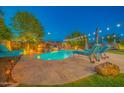 Backyard oasis with a stunning pool, complete with a rock waterfall feature and lounge seating at 9388 W Cashman Dr, Peoria, AZ 85383
