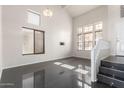 Bright living room with high ceilings, large windows, and dark flooring at 13408 W Mauna Loa Ln, Surprise, AZ 85379