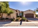 Charming single-story home with a well-manicured desert landscape and a two-car garage at 1681 E Maygrass Ln, Queen Creek, AZ 85140