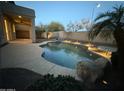 Backyard pool surrounded by desert landscaping and a covered patio area at 16823 S 27Th Ave, Phoenix, AZ 85045