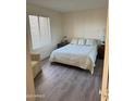 Cozy bedroom with wood floors, white walls, a plush bed and natural light from window at 17404 N 99Th Ave # 136, Sun City, AZ 85373