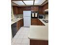 Clean and well-maintained kitchen featuring wood cabinetry and white appliances at 17404 N 99Th Ave # 136, Sun City, AZ 85373