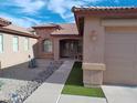 Welcoming front entrance with stone accents, a charming porch, and manicured artificial grass at 32071 N Chestnut Trl, San Tan Valley, AZ 85143