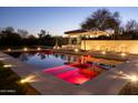 Tranquil pool with ambient lighting, lounge chairs, and serene landscaping in backyard at 3977 E Paradise View Dr, Paradise Valley, AZ 85253
