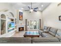 Inviting living room with fireplace, high ceilings, built-in shelves, and lots of natural light from the doors to the backyard at 4502 E Hartford Ave, Phoenix, AZ 85032
