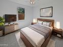 Cozy main bedroom showcases a stylish bed frame, soft lighting, and a decorative wall art piece at 4806 N 186Th Ln, Goodyear, AZ 85395