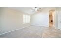 Bright, carpeted bedroom features a ceiling fan and window with plantation shutters at 7923 W Taro Ln, Glendale, AZ 85308