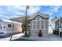 Charming home featuring covered parking, a cozy seating area, and lush palm trees against a bright blue sky at 834/837 S Beryl/Aquamarine Dr, Apache Junction, AZ 85119