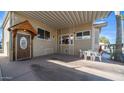 Inviting covered porch featuring a decorative wood door and cozy seating area, perfect for enjoying the outdoors at 834/837 S Beryl/Aquamarine Dr, Apache Junction, AZ 85119