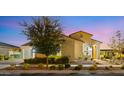 Stunning single-story home exterior with mature tree, desert landscaping, and warm lighting at 10455 E Thatcher Ave, Mesa, AZ 85212