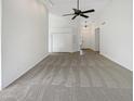 Open-concept living room featuring carpet, ceiling fan, and light color walls at 1517 E Piute Ave, Phoenix, AZ 85024