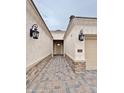 Home walkway with brick pavers and exterior sconces leading to the front door at 1586 N Himosa Dr, Casa Grande, AZ 85122