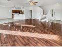 Open living room with wood floors, a ceiling fan, and an open-concept kitchen at 17649 W Young St, Surprise, AZ 85388