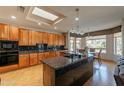 Updated kitchen featuring granite counters, stainless steel appliances, wood cabinets, and a center island at 18215 N Shadow Ct, Surprise, AZ 85374