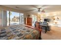 Relaxing primary bedroom with a ceiling fan, sitting area, and sliding door access to the backyard at 18215 N Shadow Ct, Surprise, AZ 85374